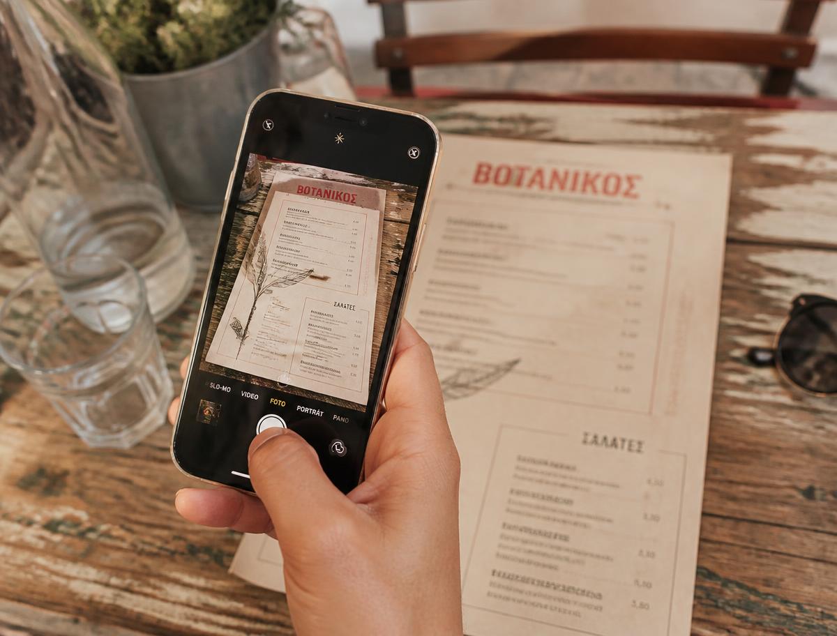 Traveller photographing a foreign-language restaurant menu with a phone
